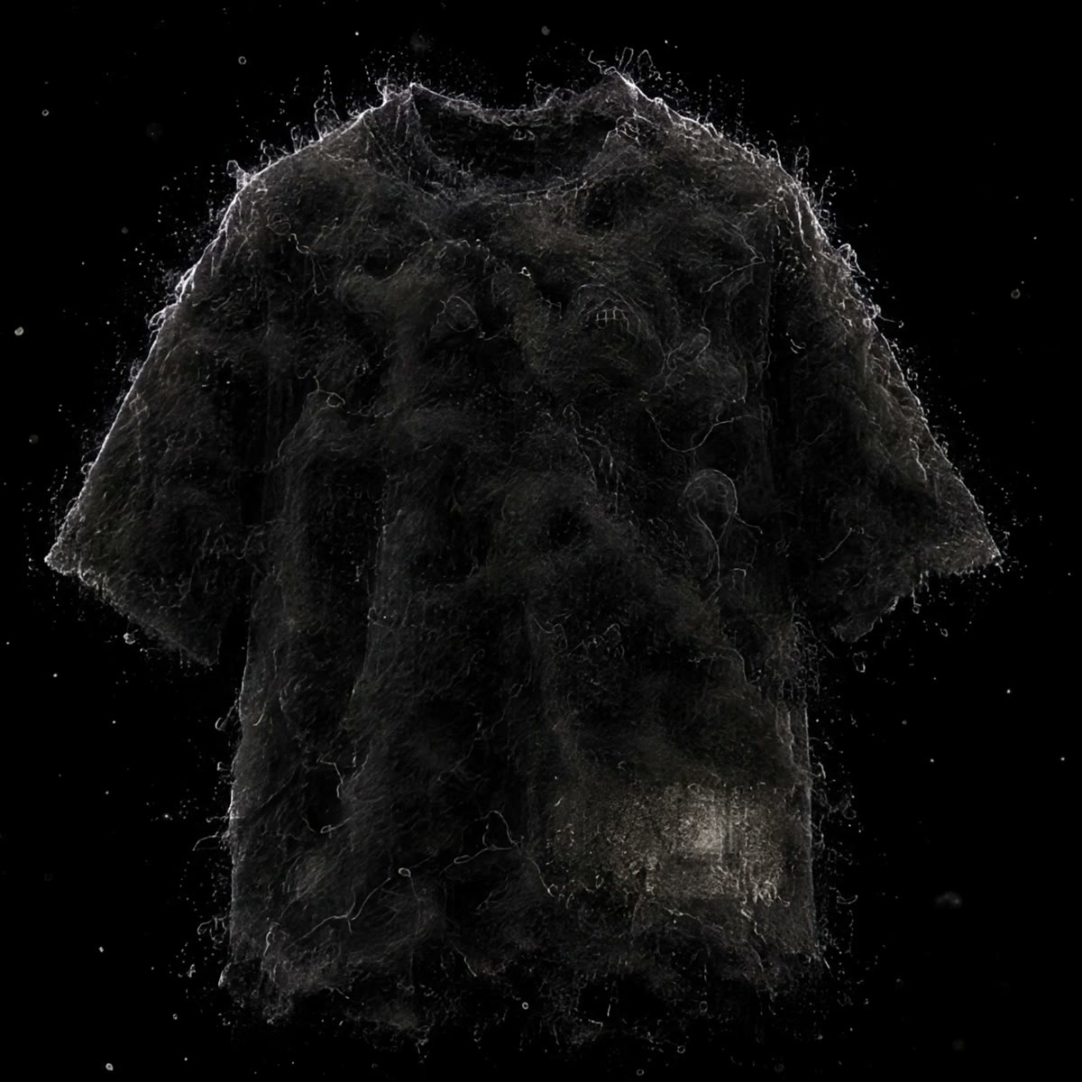 The shirt as loose dust on black — no fixed shape yet
